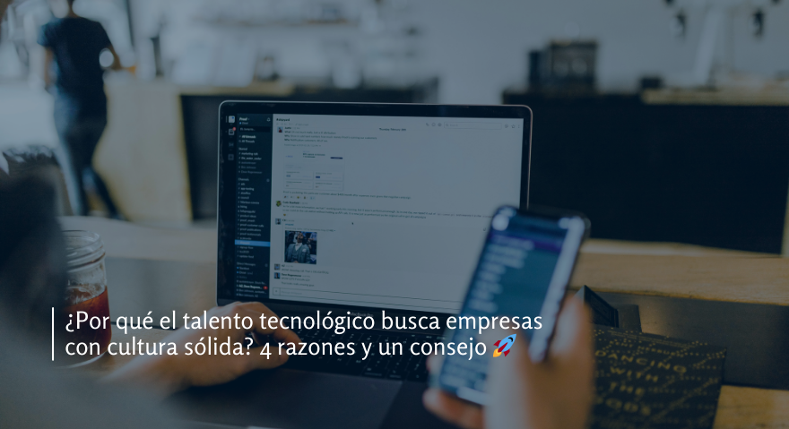 Profesional tecnológico usando una ordenador portátil y un smartphone en un espacio de trabajo moderno, representando la búsqueda de empresas con cultura organizacional sólida.